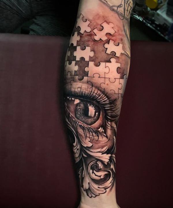 Puzzles and realistic eye with swirls tattoo