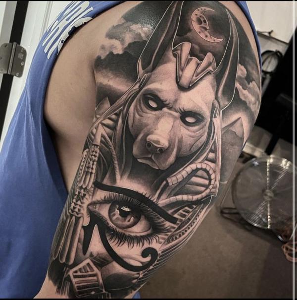 Realistic Anubis and Eye of Horus half sleeve tattoo