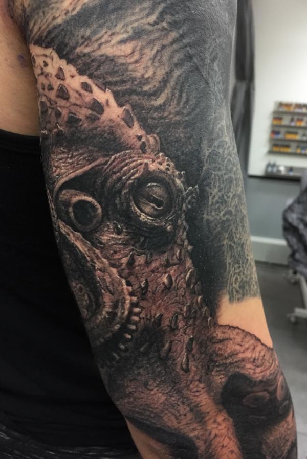 Realistic kraken head tattoo on back of arm