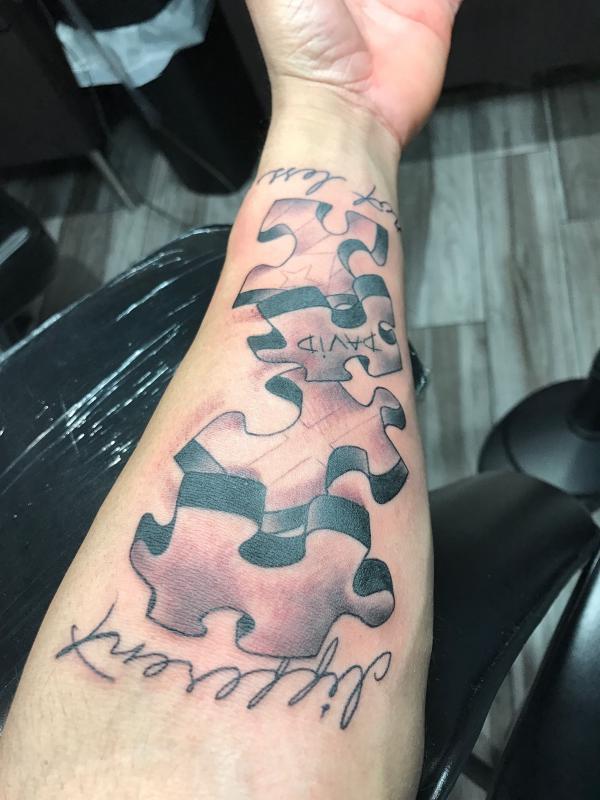Realistic three puzzle forearm tattoo