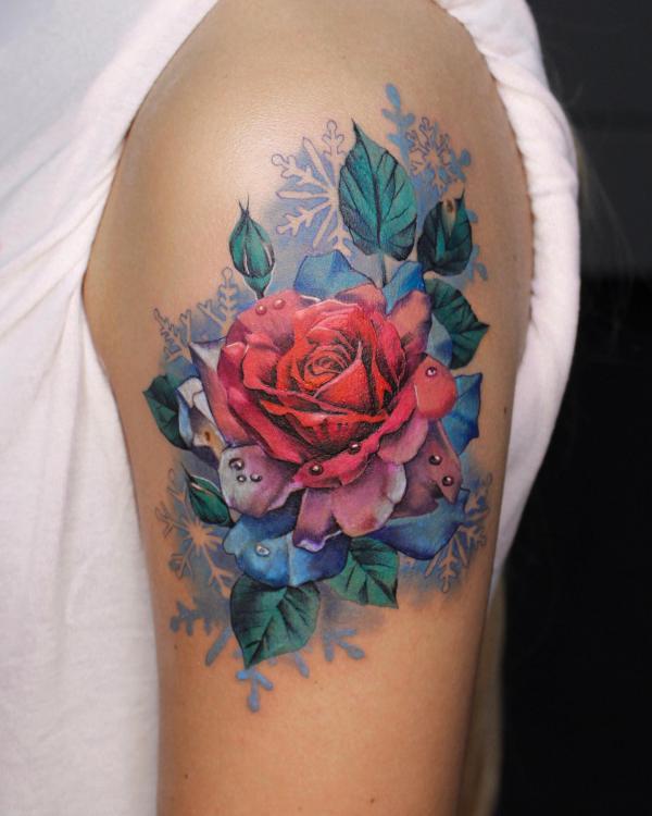 Rose on snowflake backdrop shoulder tattoo