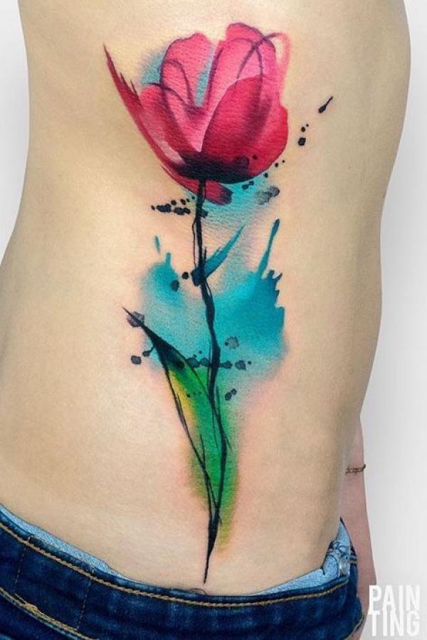 SIngle watercolor poppy flower tattoo on rib cage