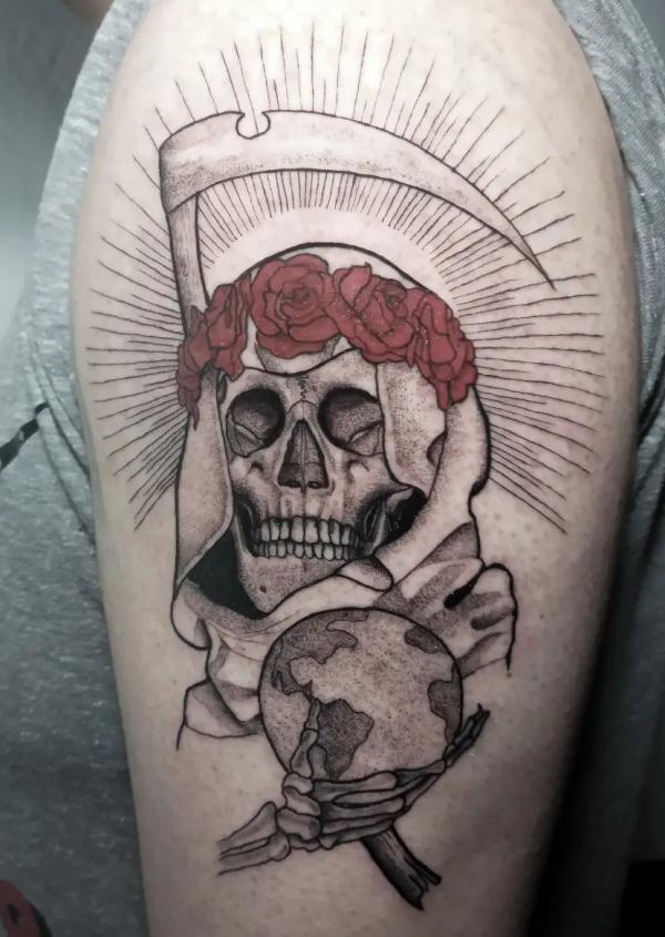 Santa Muerte holding scythe and globe tattoo on upper arm
