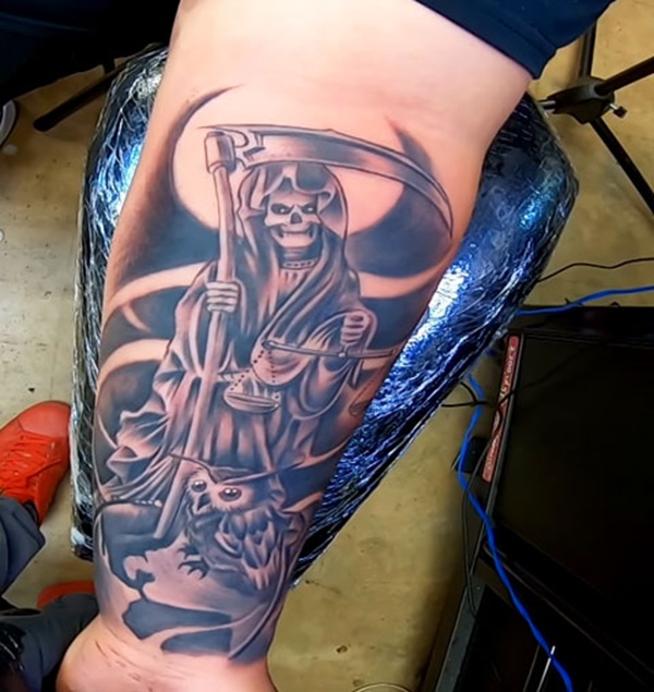 Santa Muerte holding scythe and scales of justice with owl tattoo