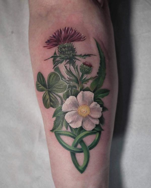 Shamrock and thistle tattoo on inner forearm