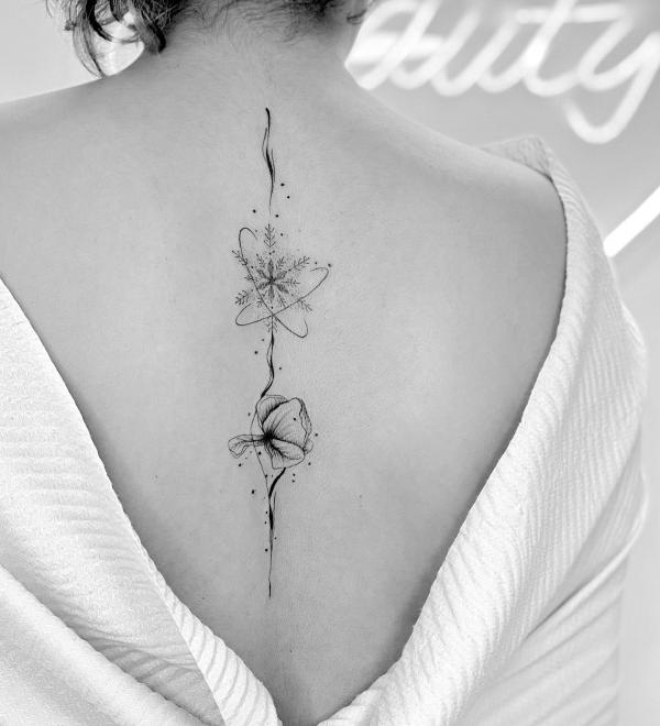 Simple snowflake and flower spine tattoo