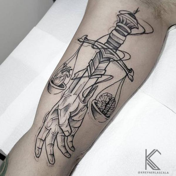 Skull and heart on Scales of justice and a dagger pierced a hand tattoo
