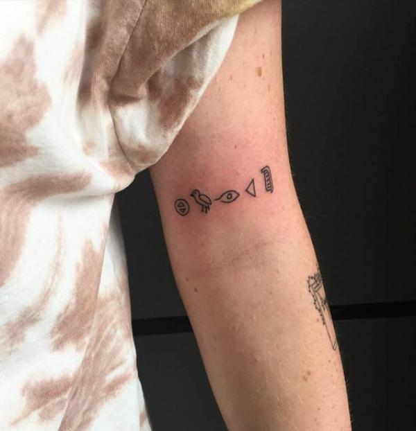 Small Hieroglyphics tattoo on upper arm