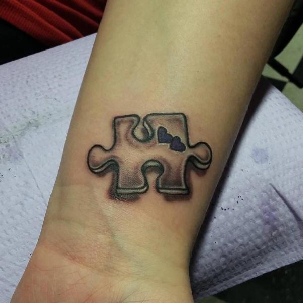 Small puzzle with tiny hearts tattoo