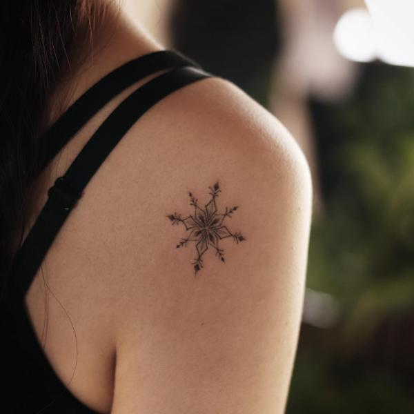 Small snowflake shoulder tattoo