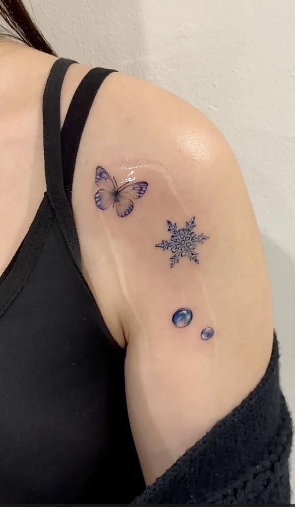Snowflake and butterfly tattoo on shoulder