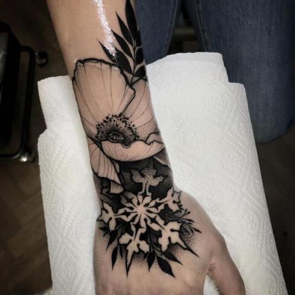 Snowflake and flower hand and wrist tattoo