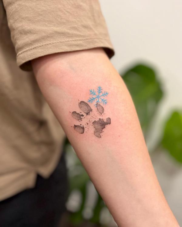 Snowflake and pawprint inner elbow tattoo