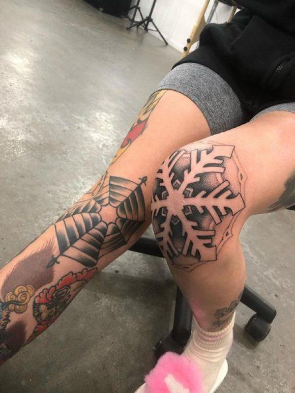 Snowflake and spider web knee tattoos