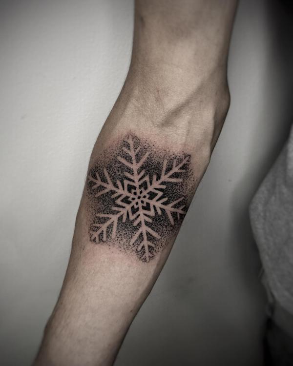 Snowflake dotwork tattoo below elbow