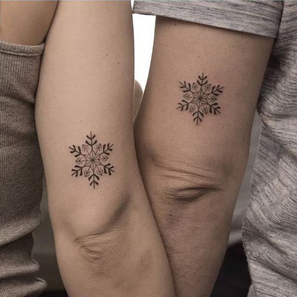 Snowflake matching tattoo above elbow