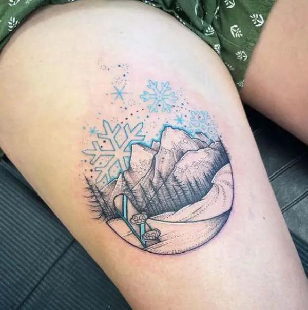 Snowflake mountain with skis thigh tattoo