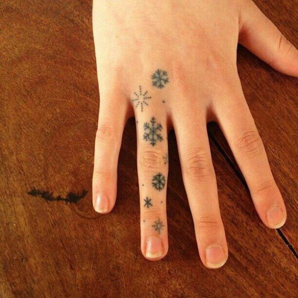 Snowflake ring finger tattoo