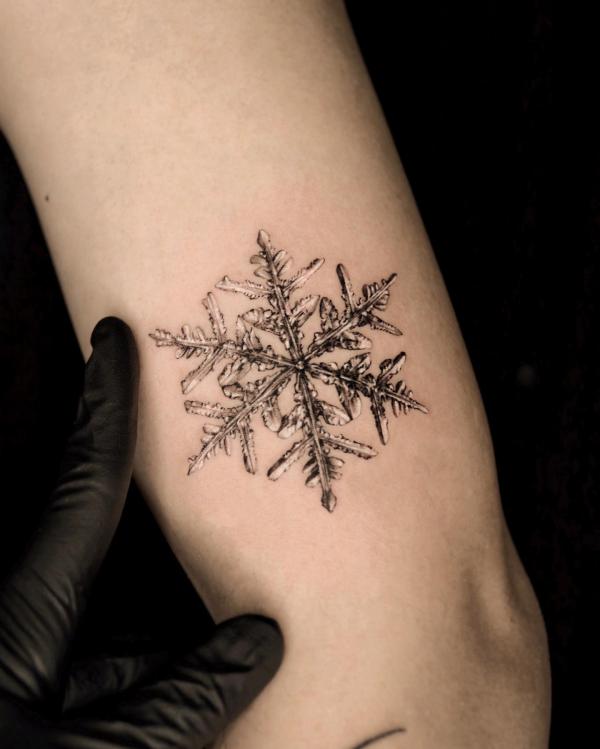 Snowflake tattoo on upper arm
