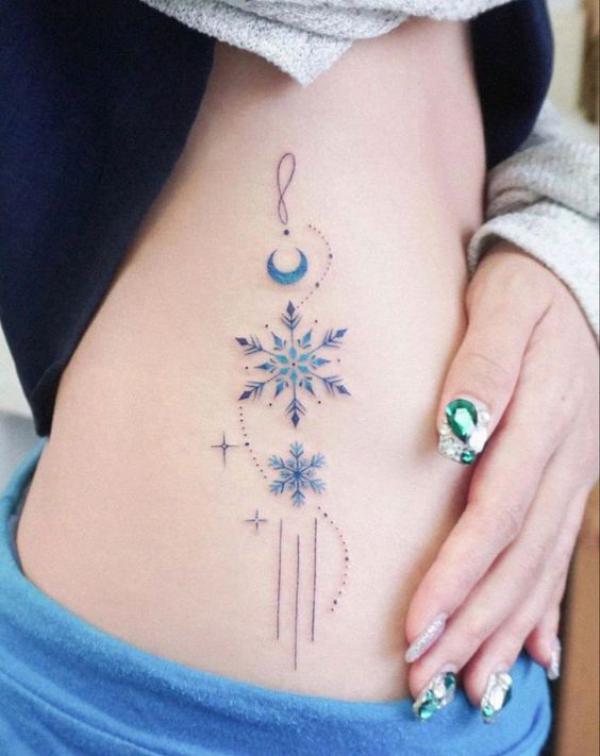 Snowflake with moon and stars tattoo on side