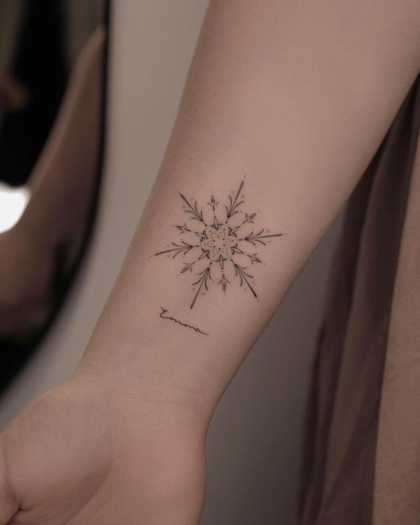 Snowflake wrist tattoo with cursive word