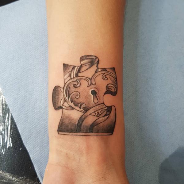 Swirling heart puzzle tattoo