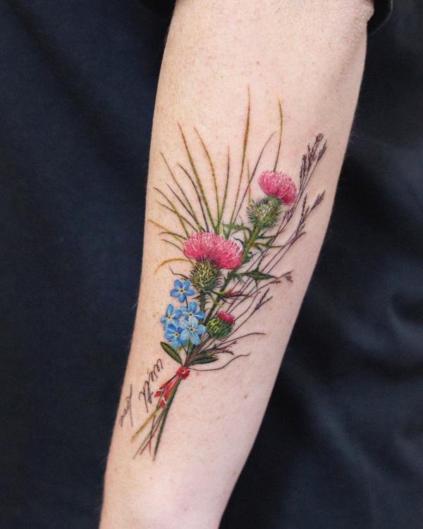 Thistle and forget me not flower tattoo