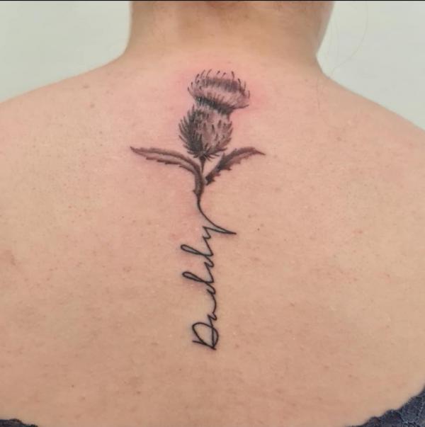 Thistle spine tattoo with word
