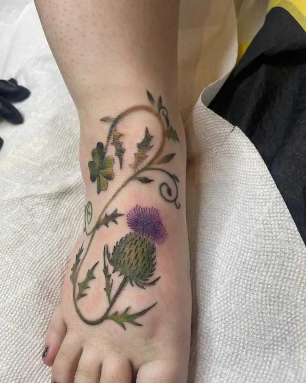 Thistle with shamrock and vine tattoo on foot