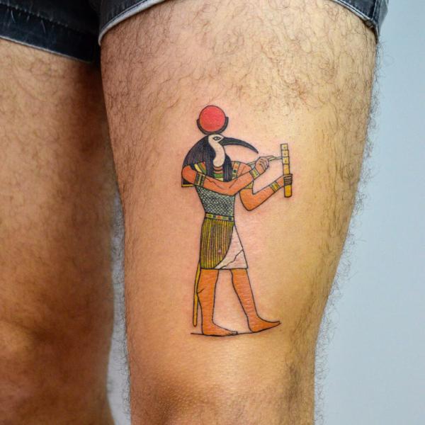 Thoth holding a stylus to write thigh tattoo