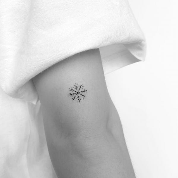 Tiny snowflake elbow tattoo