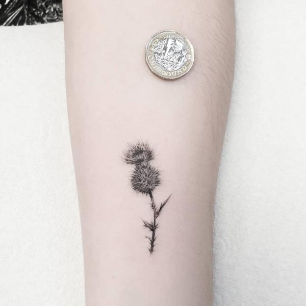 Tiny thistle and coin tattoo