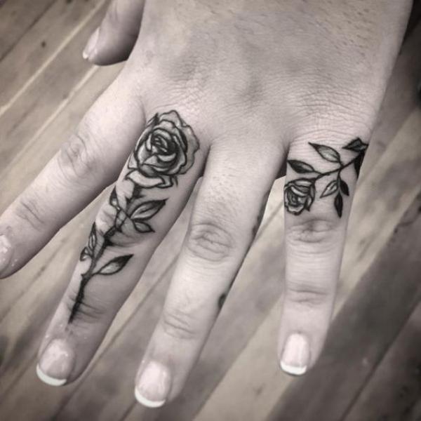 Two roses tattoos on middle and little finger