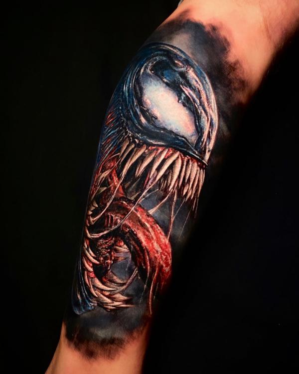 Venom tattoo on outer forearm
