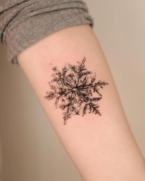 Vintage snowflake tattoo on bicep
