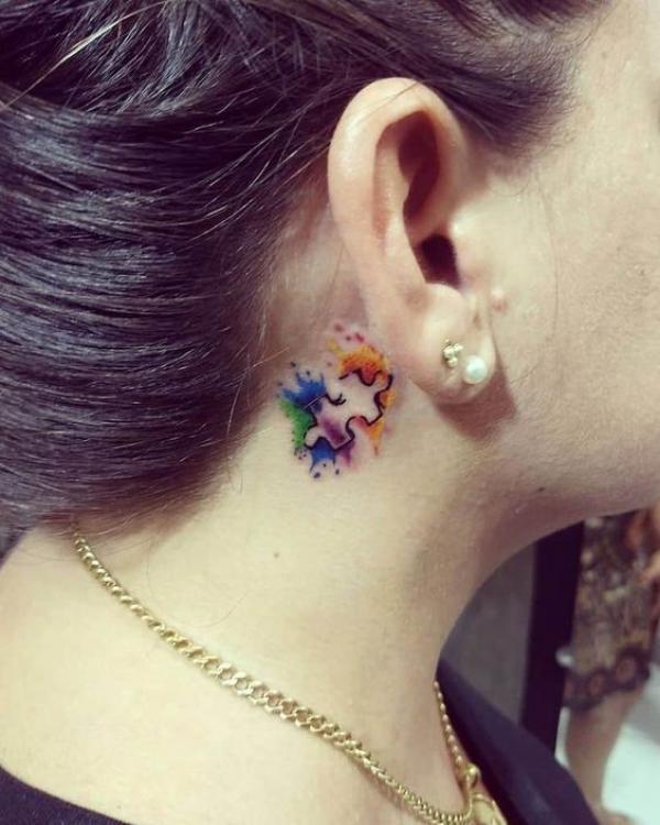 Watercolor puzzle tattoo behind ear