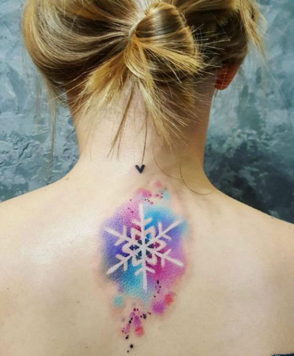 Watercolor snowflake tattoo on upper back