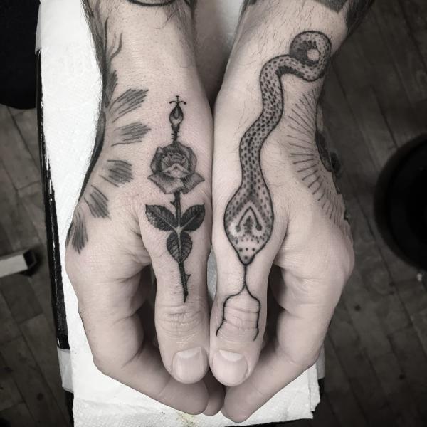 black and grey rose and snake tattoo on thumb fingers