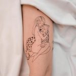 A woman huging a leopard outline tattoo