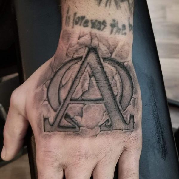 Alpha and omega stone christian hand tattoo