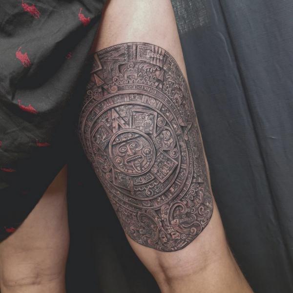 Aztec calendar above knee tattoo