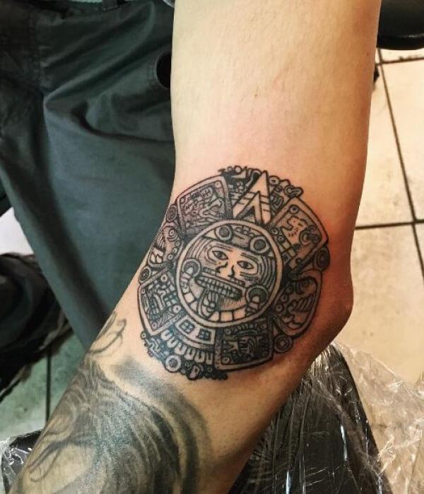 Aztec calendar tattoo on the side of elbow