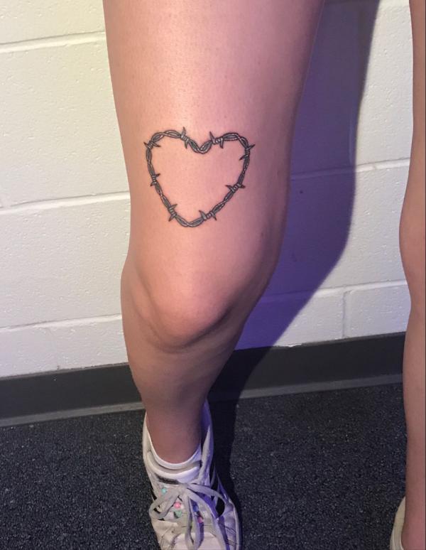 Barbed wire heart above knee tattoo