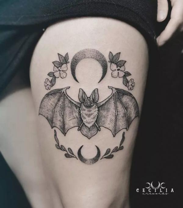 Bat and crescent moon above knee tattoo