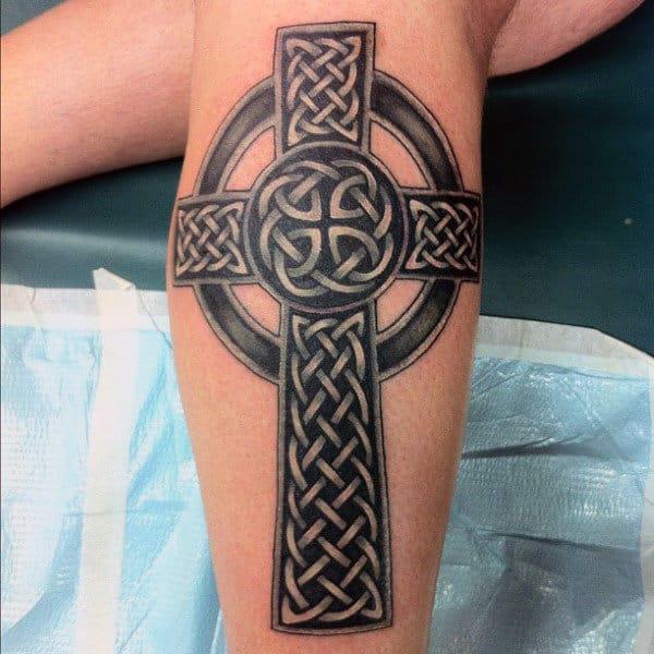 Black and grey Celtic cross with Dara calf tattoo