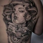 Black and grey Medusa tattoo on one side of back