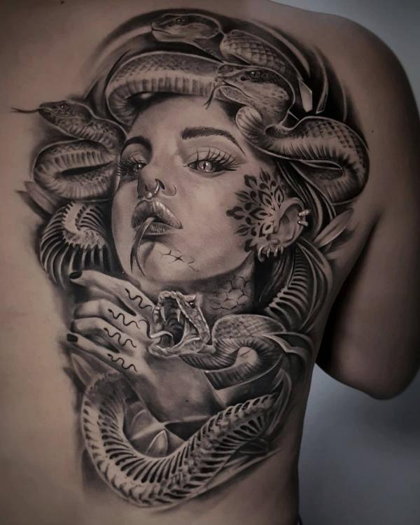 Black and grey Medusa tattoo on one side of back