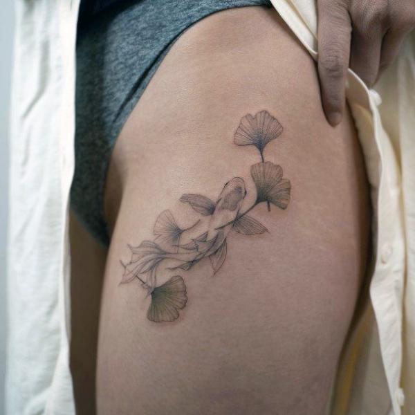 Black and grey ginkgo leaves tattoo on the side of hip