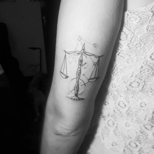 Black and grey libra constellation tattoo above elbow