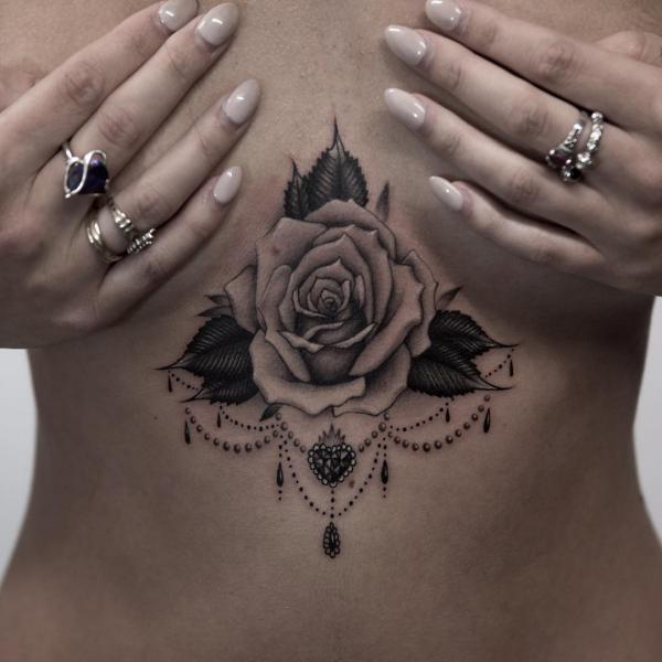 Black and grey rose with tiny sacred heart pendant sternum tattoo